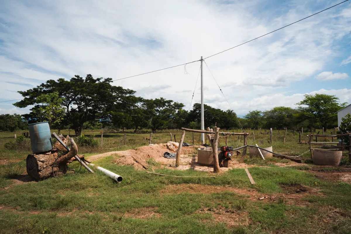 A hand-dug well and pump in an open field