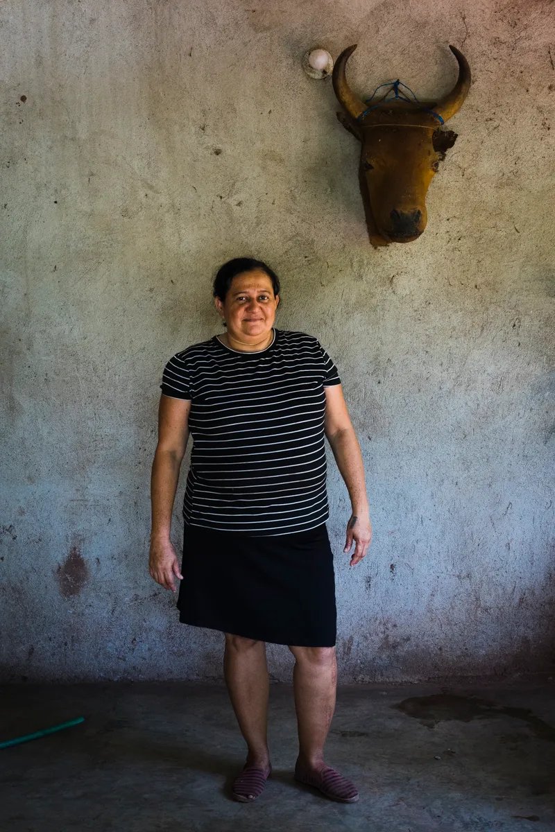 A woman standing beneath a mounted bull's skull