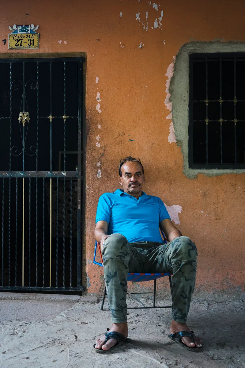 A man seated outside his house in town